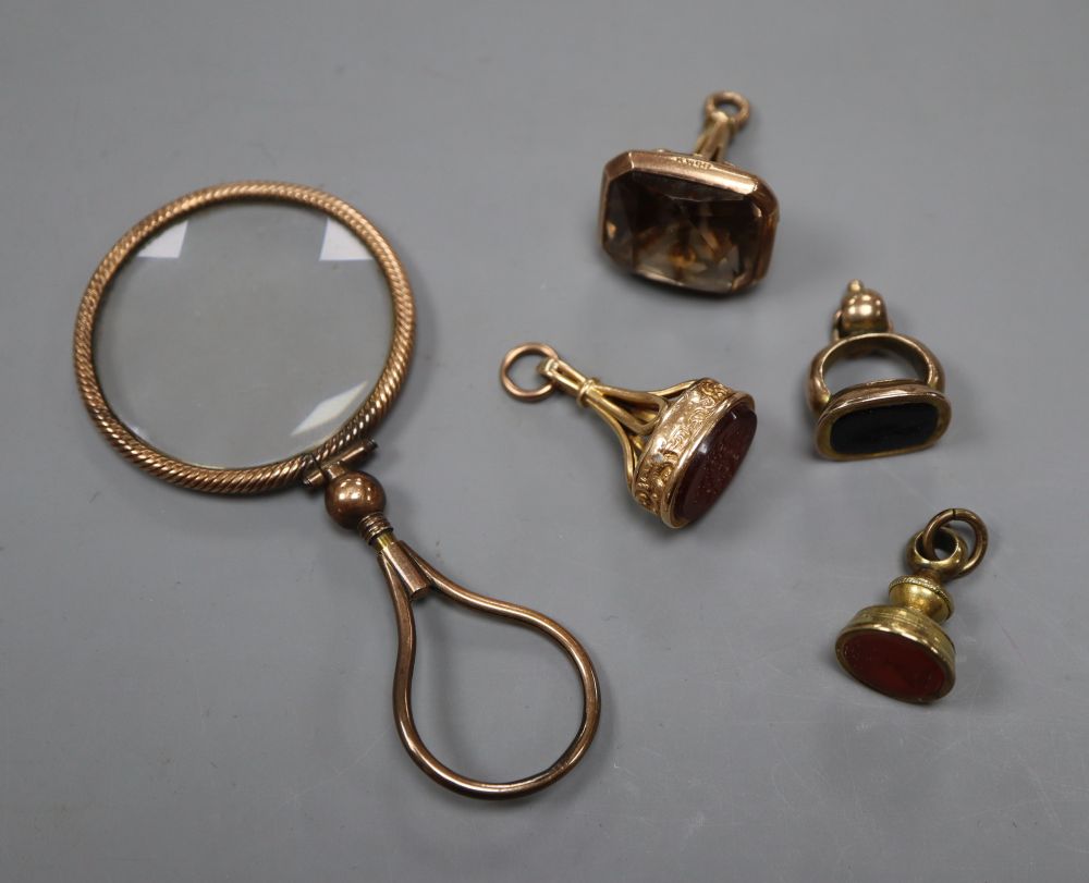 A 9ct mounted smoky quartz fob seal, 28mm, two yellow metal overlaid fob seals, a gilt fob seal and a magnifying glass.